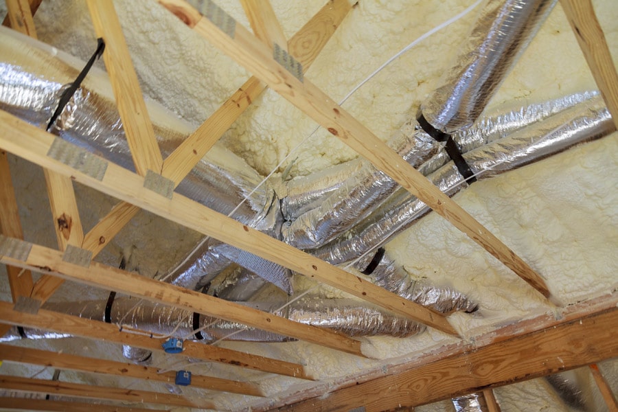 A new home attic construction with spray foam insulation and pipes in San Antonio TX