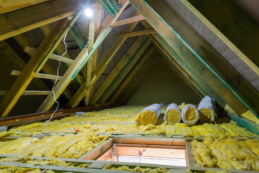 Empty attic in the house with rolls insulation